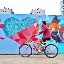 Boy on bicycle in front of urban mural Boy on bicycle in front of urban mural